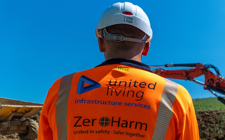 construction worker on sight overlooking digger
