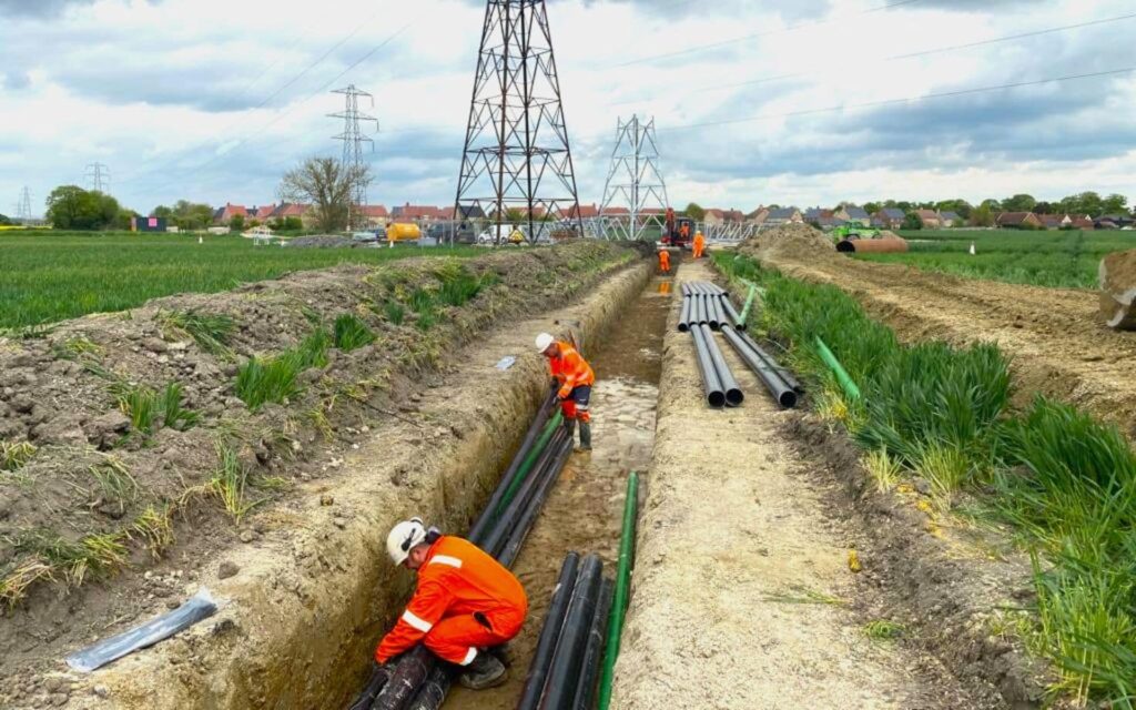 employees working in ground installing underground cables