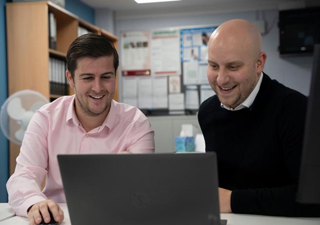 two employees looking at laptop