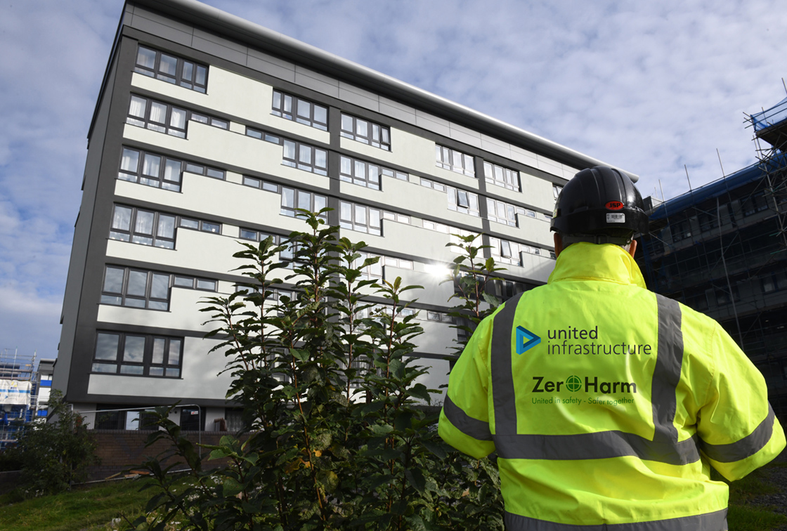 EMPLOYEE STANDING IN FRONT OF RESIDENTIAL BUILDING