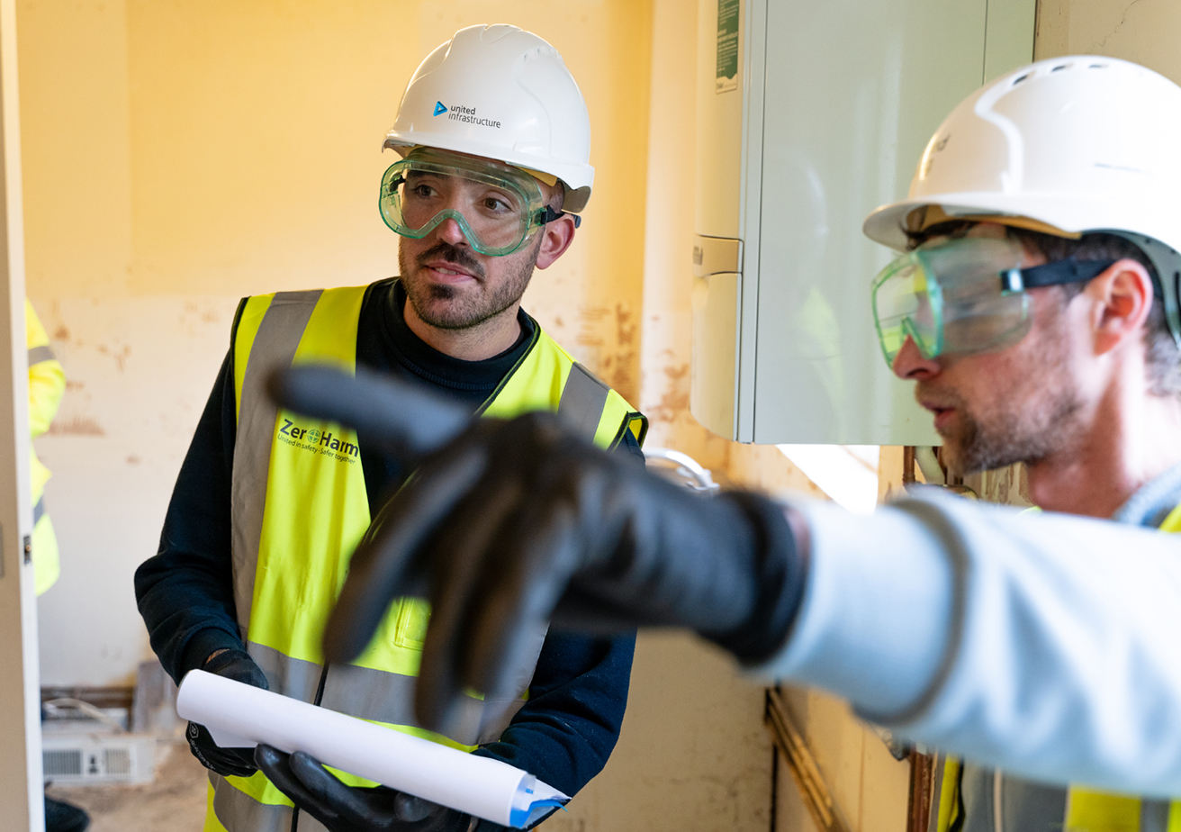 united infrastructure employees wearing ppe and talking in building