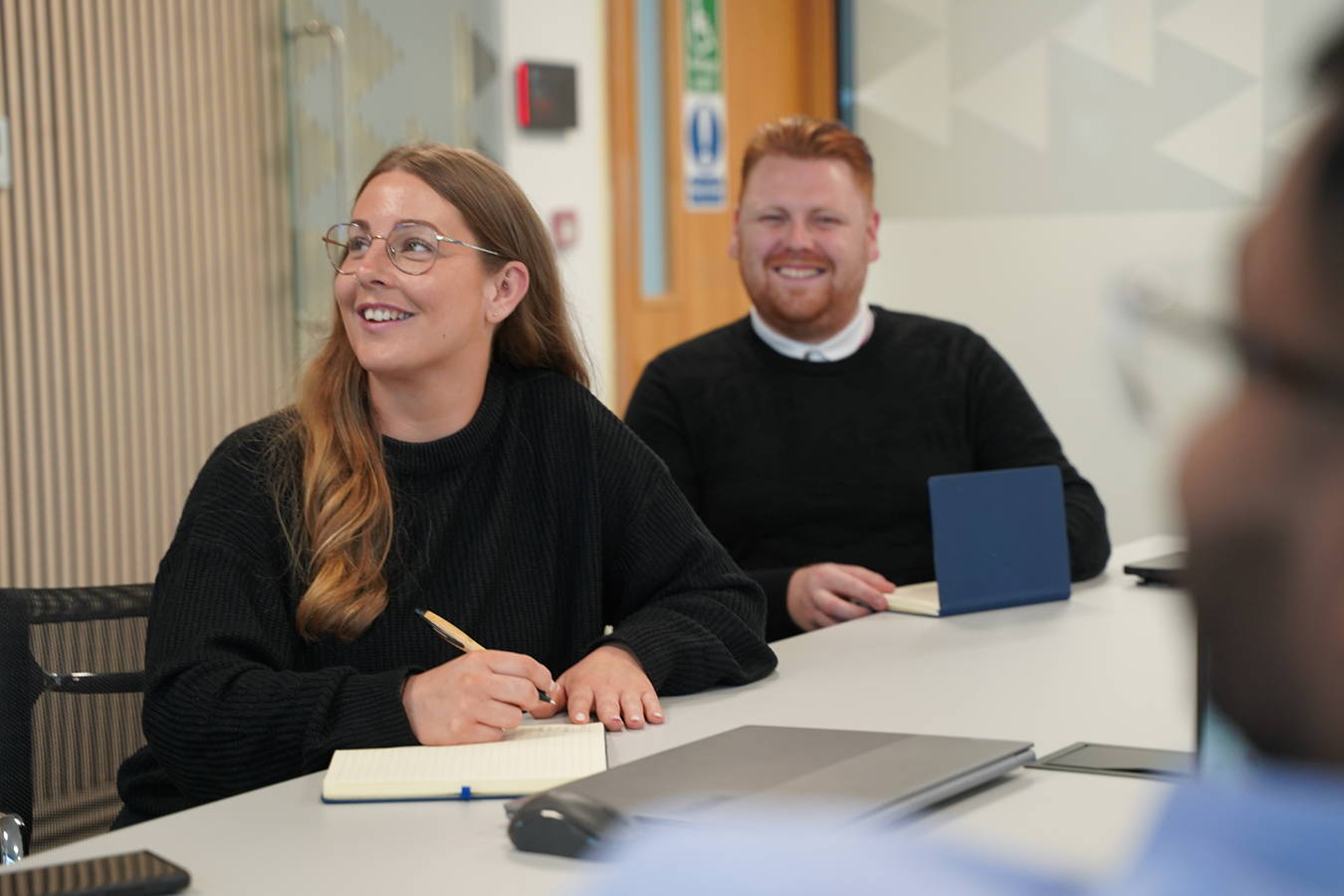 apprentices sat round meeting table with notebooks