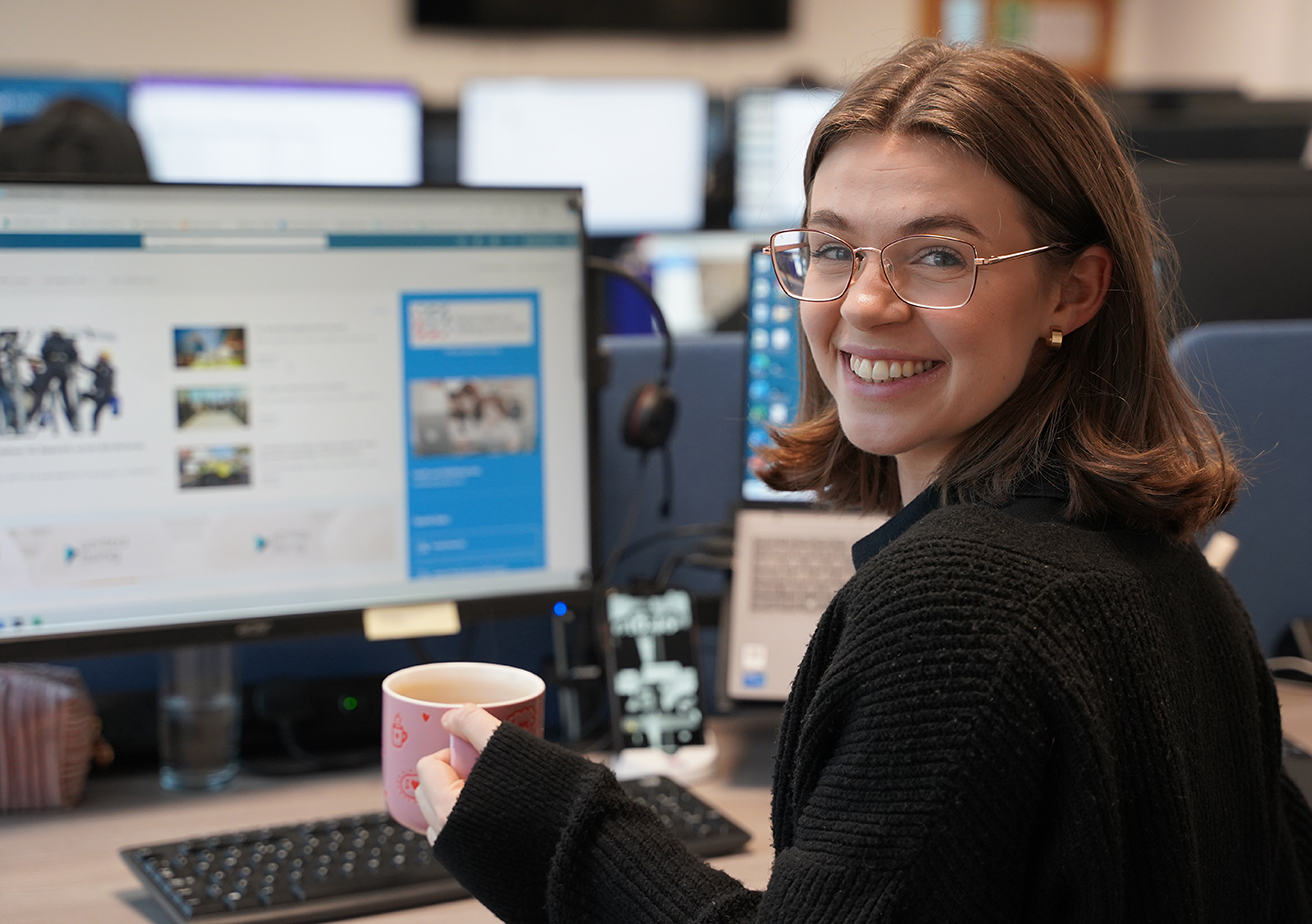 employee sat in front of computer and smiling