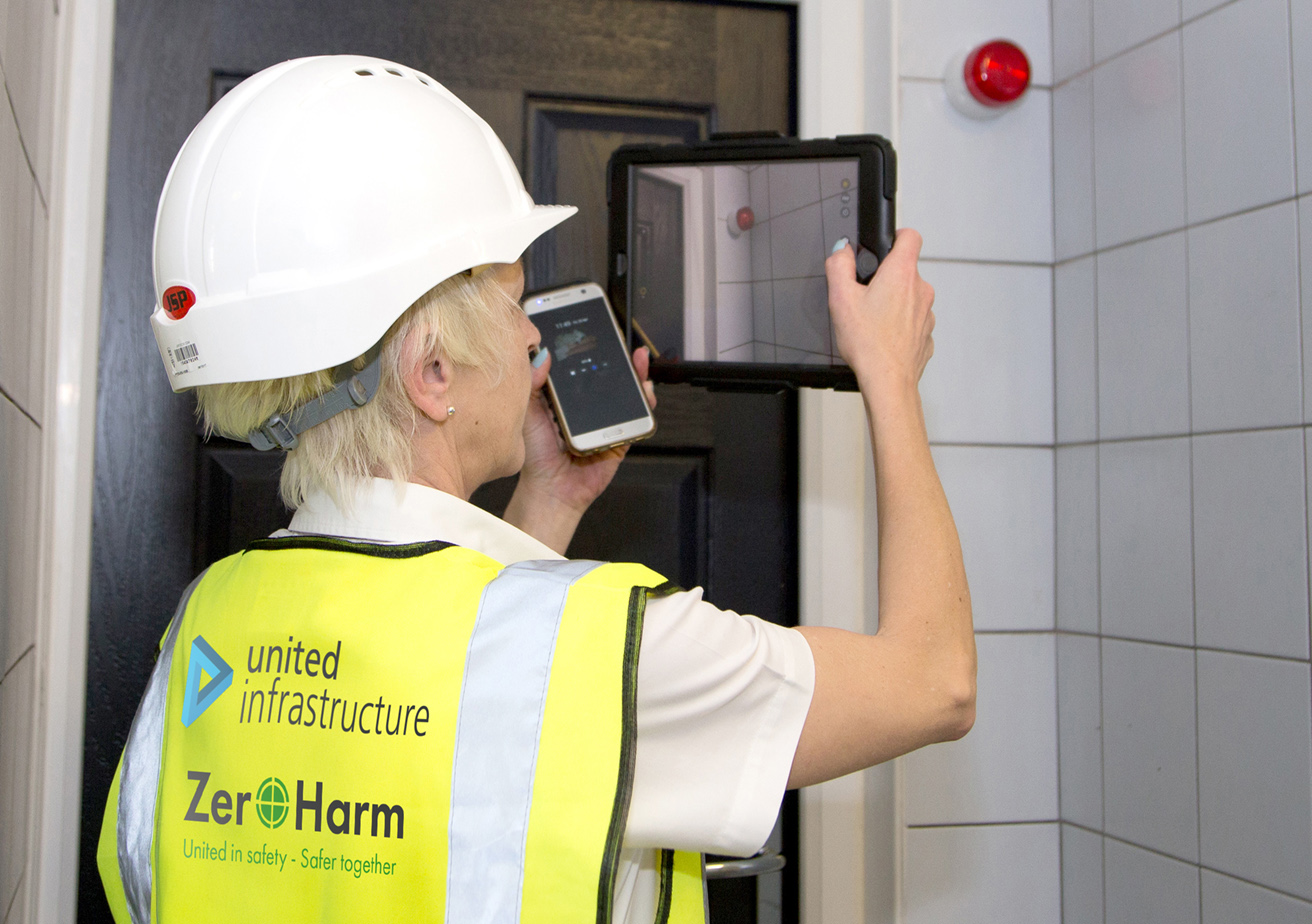 united infrastructure employee using ipad to take photos of room