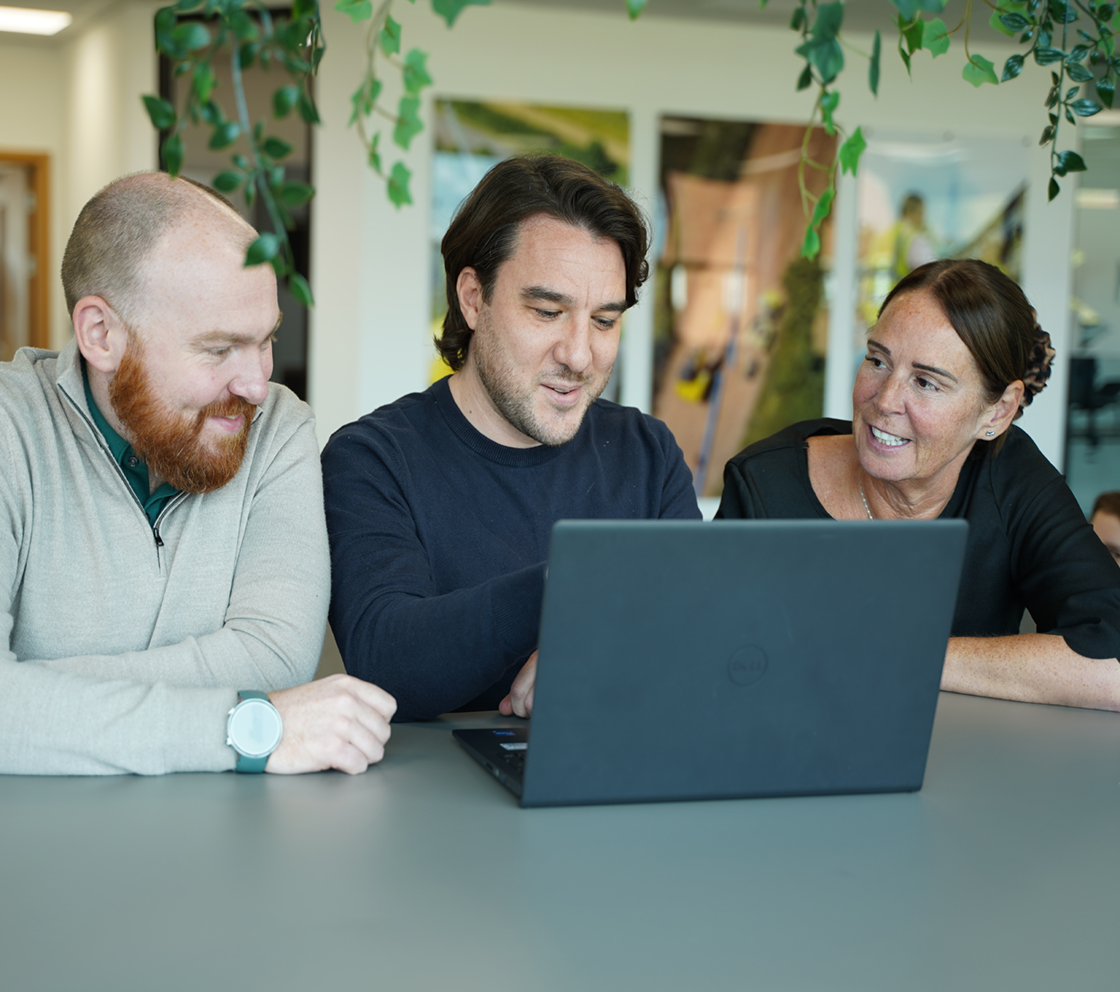 group of employees sat around a laptop