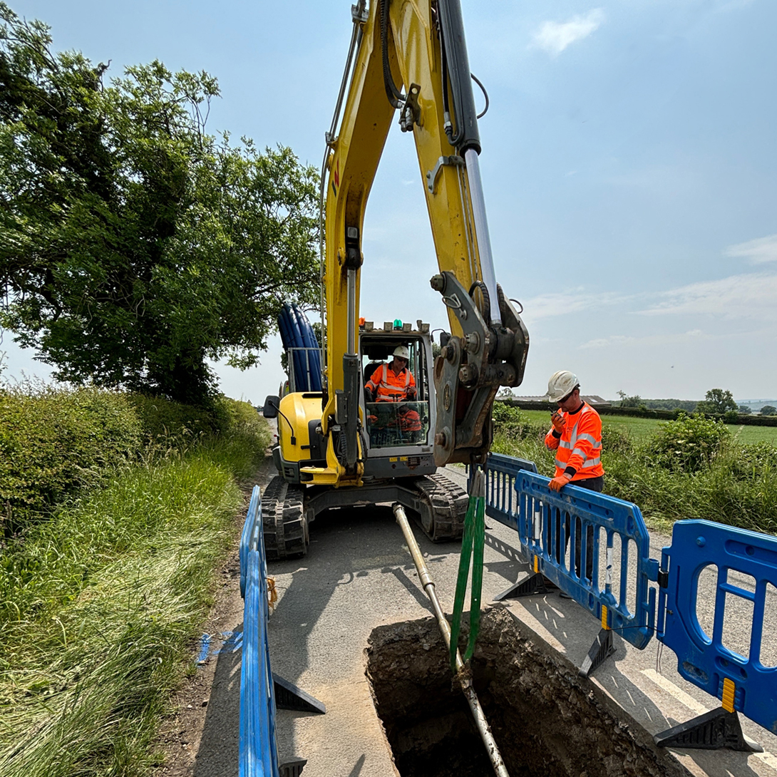 united infrastructure employee operating a digger and excavating ground
