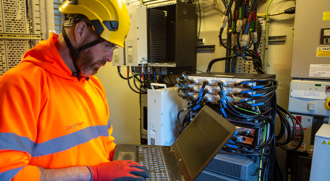 EMPLOYEE WORKING ON LAPTOP IN CONTROL ROOM
