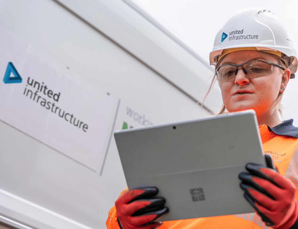 Employee standing in front of van in pee and holding an electronic tablet